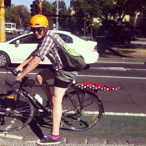 danni on a bike; she is at a stop at an intersection, and her bike is located in the bike lane.