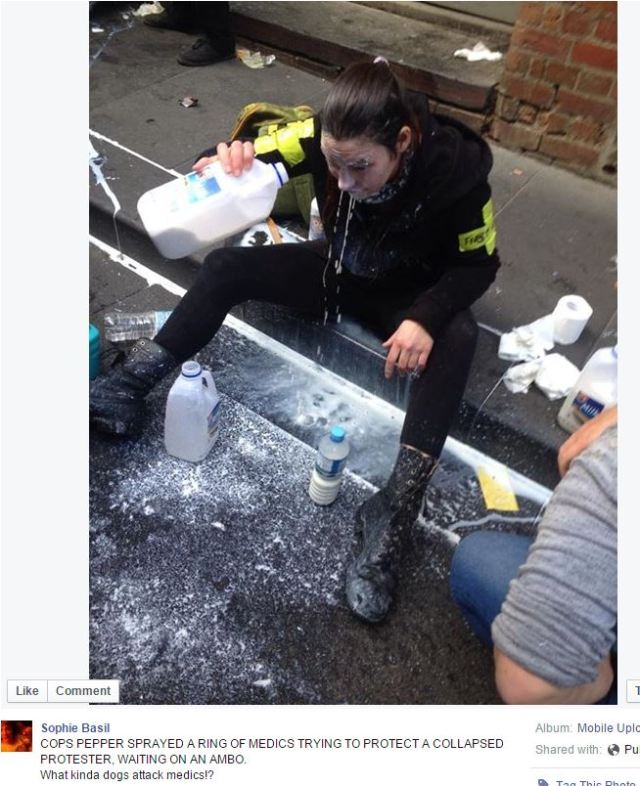 photo of a medic washing their face with milk after being pepper sprayed by a copper